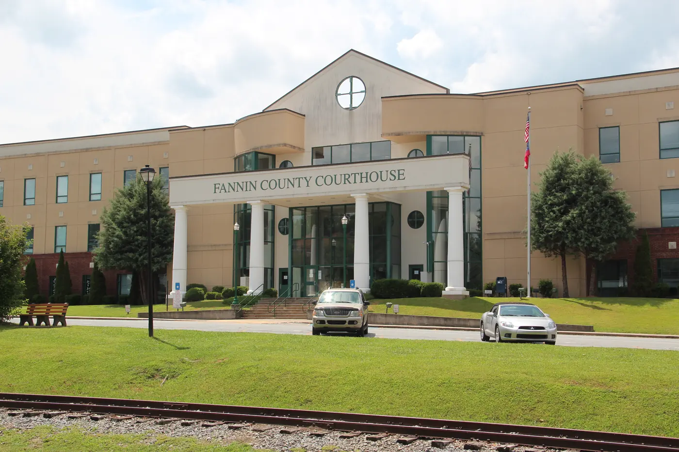 Cream-colored courthouse with a columned entry and a sign reading Fannin County Courthouse